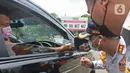 Petugas memeriksa pengendara mobil saat pemberlakuan aturan ganjil-genap di pos sekat Gerbang Tol Bogor, Kota Bogor, Jawa Barat, Sabtu (6/2/2021). Pemerintah Kota Bogor mulai menerapkan aturan ganjil-genap di setiap akhir pekan bagi kendaraan roda dua maupun empat. (Liputan6.com/Herman Zakharia)