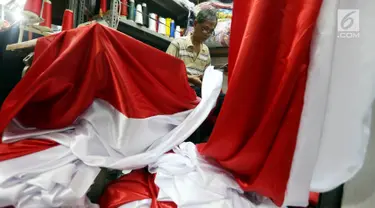 Seorang penjahit mengerjakan pesanan bendera merah putih di Pasar Senen, Jakarta, Selasa (9/8). Jelang peringatan HUT Republik Indonesia ke-72 para penjahit di Pasar Senen mengalami peningkatan pemesanan bendera merah putih. (Liputan6.com/Johan Tallo)