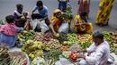 Pelanggan membeli buah-buahan di pinggir jalan menjelang festival Hindu Chhath, di Kolkata, India (9/11/2021). Selama Chhath, festival Hindu kuno yang populer di kalangan kelas pekerja, ritual dilakukan untuk berterima kasih kepada Dewa Matahari atas menopang kehidupan di bumi. (AP Photo/Bikas Das)