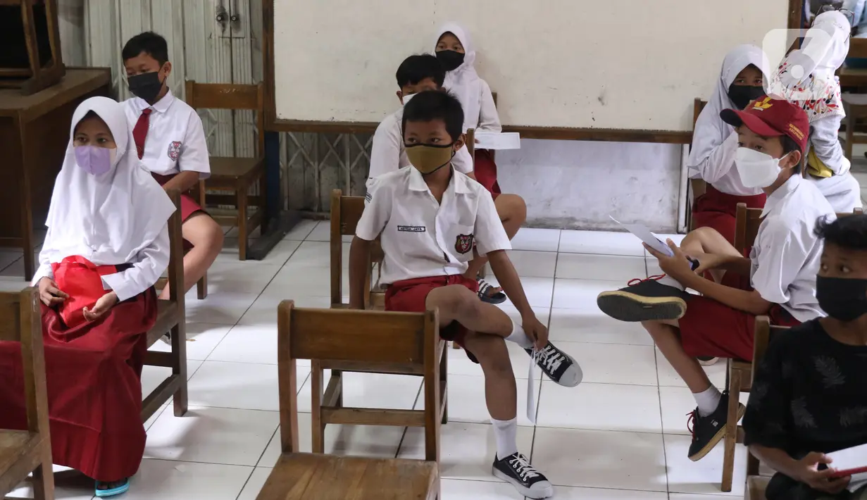 Sejumlah siswa menunggu antrean saat melakukan vaksinasi COVID-19 Pfizer di SDN Panunggangan 5, Pinang, Kota Tangerang, Selasa (19/10/2021).  Pelaksanaan vaksinasi untuk pelajar usia 12 tahun ini dilakukan dalam rangka persiapan pelaksanaan pembelajaran tatap muka (PTM). (Liputan6.com/Angga Yuniar)