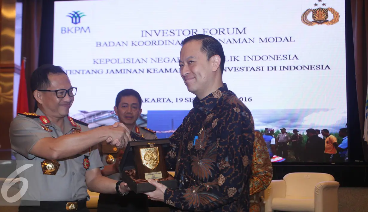 Kapolri Jenderal Polisi Tito Karnavian dan Kepala BKPM Thomas Lembong bertukar cindera mata, Jakarta, Senin (19/9). Acara ini merupakan wujud pedoman kerja tentang koordinasi perlindungan dan keamanan bagi dunia usaha. (Liputan6.com/Immanuel Antonius)