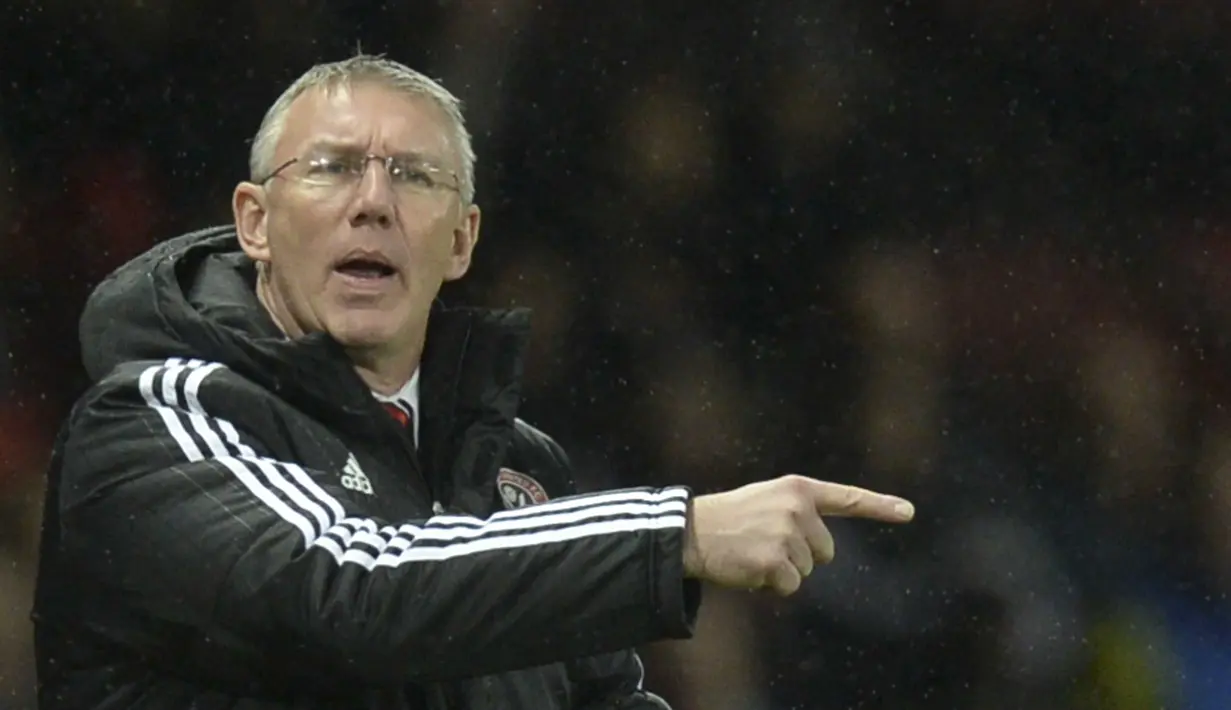 Pelatih Sheffield United, Nigel Adkins  memberikan instruksi kepada anak asuhnya saat melawan Manchester United pada laga Piala FA di Old Trafford, Minggu (10/1/2016) dini hari WIB. (AFP Photo/ Oli Scarff)