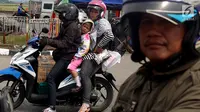 Pemudik sepeda motor dengan membawa anak mengantre untuk mengisi bahan bakar di SPBU kawasan Pantura di wilayah Brebes, Jawa Tengah, Kamis (22/6). Meski berbahaya, sejumlah pemudik masih nekat membawa anak mereka dengan motor. (Liputan6.com/Johan Tallo)