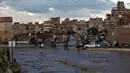 Sejumlah warga melihat jalanan yang terendam banjir di Sanaa, Yaman, Selasa (2/8). Hujan lebat yang mengguyur Sanaa membuat salah satu ruas jalan di kota itu berubah seakan menjadi sungai. (REUTERS / Khaled Abdullah)