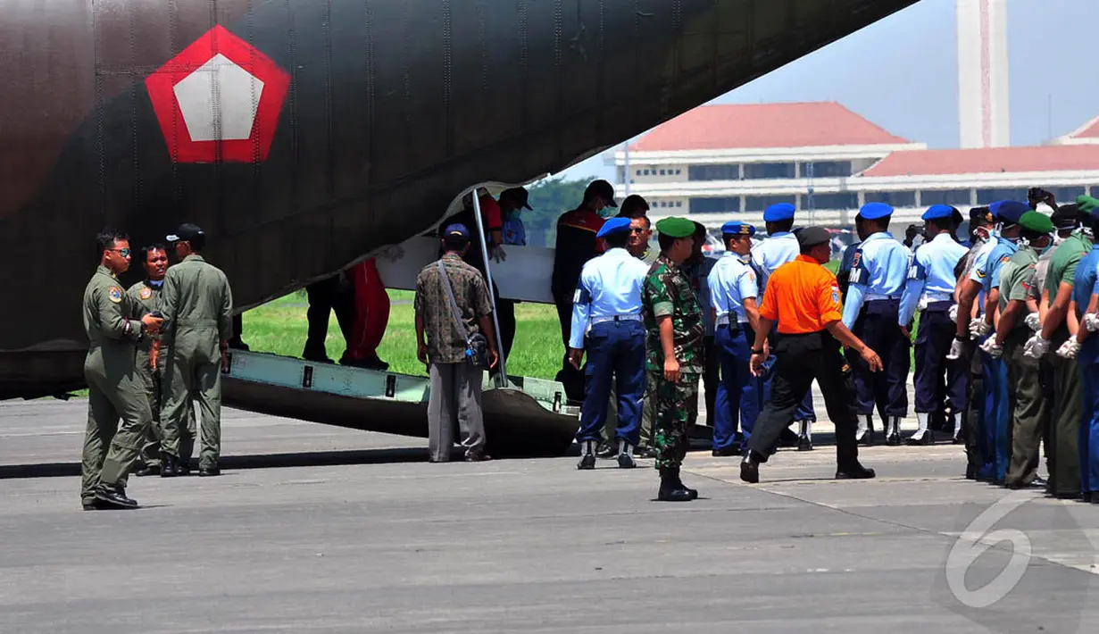 Petugas saat menurunkan empat peti jenazah korban pesawat AirAsia QZ8501 di Lanud TNI AL Juanda, Surabaya, Kamis (1/1/2015). (Liputan6.com/Johan Tallo)