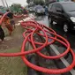 Pekerja merapikan kabel jaringan utilitas ke dalam tanah di kawasan Kemayoran, Jakarta, Minggu (14/1). PT PLN Disjaya akan menertibkan kabel listrik yang ada di tiang-tiang dengan menanam kabel di bawah tanah. (Liputan6.com/Immanuel Antonius)