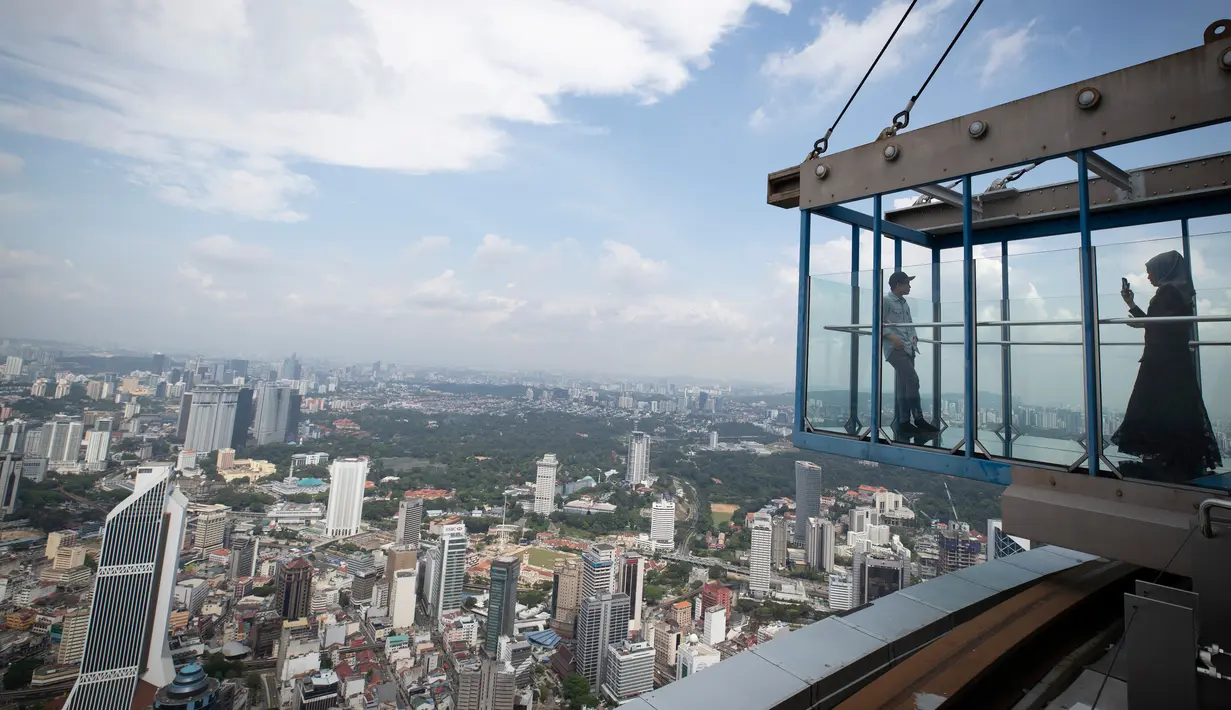Turis dengan mengenakan masker mengambil gambar dari dek obseravsi di Menara Kuala Lumpur di Kuala Lumpur, Rabu (1/7/2020). Malaysia memasuki pelonggaran Perintah Kontrol Gerakan (MCO) setelah tiga bulan pembatasan karena virus corona Covid-19. (AP Photo/Vincent Thian)