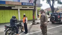 Tim Satgas Covid-19 Kabupaten Grobogan saat menghentikan pengendara yang nekat keluar rumah tanpa kenakan masker saat program sehari dirumah saja. (Foto: Liputan6.com/Felek Wahyu)