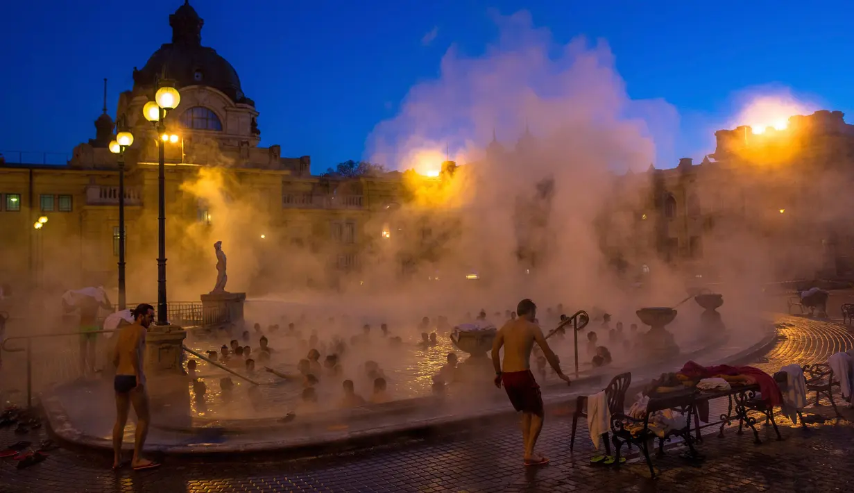 Pengunjung menikmati uap air panas yang mengepul dari kolam Szechenyi Thermal Bath di Budapest, Hongaria, 7 Januari 2017. Ratusan ribu orang tiap tahunnya berkunjung dan karena suhu airnya, kebanyakan datang ketika musim dingin. (Bea Kallos/MTI via AP)