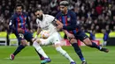 Pemain Real Madrid Karim Benzema (tengah) mengontrol bola saat mempertahan bola dari pemain Barcelona Ronald Araujo (kanan) dan Jules Kounde pada pertandingan sepak bola leg pertama semifinal Copa del Rey di Stadion Santiago Bernabeu, Madrid, Spanyol, 2 Maret 2023. Barcelona sukses megalahkan Real Madrid dengan skor 1-0 berkat gol bunuh diri Eder Militao. (AP Photo/Bernat Armangue)