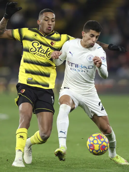 Bek Manchester City, Joao Cancelo berebut bola dengan pemain Watford, Joao Pedro pada pertandingan lanjutan Liga Inggris di Stadion Vicarage Road di Watford, Inggris (4/12/2021). City menang atas Watford 3-1. (AP Photo/Ian Walton)