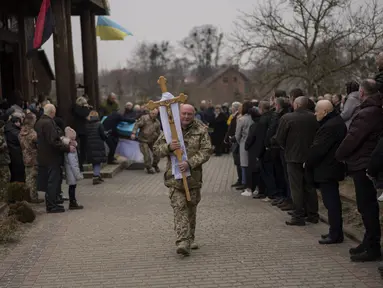 Orang-orang menghadiri upacara pemakaman prajurit militer Ukraina Roman Rak dan Mykola Mykytiuk di Starychi, Ukraina barat, Rabu (16/3/2022). Rak dan Mykytiu tewas dalam serangan rudal Rusia hari Minggu di sebuah pangkalan pelatihan militer di Yavoriv. (AP Photo/Bernat Armangue)