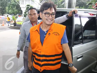 Senyum Andi Zulkarnaen Mallarangeng alias Choel Mallarangeng setibanya di Gedung KPK, Jakarta, Selasa (14/2). Tersangka kasus dugaan korupsi proyek Hambalang itu menjalani pemeriksaan perdana setelah resmi menjadi tahanan KPK. (Liputan6.com/Helmi Afandi)