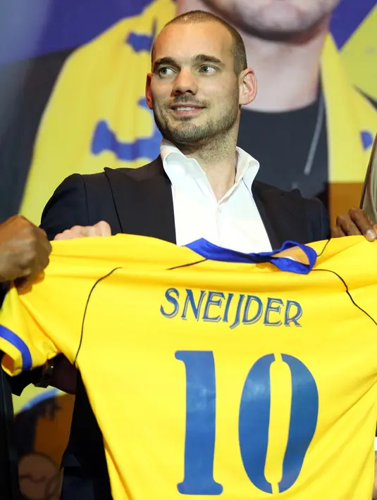 Pemain internasional Belanda, Wesley Sneijder memegang jersey nomor 10 saat diperkenalkan sebagai pemain baru klub Qatar, Al Gharafa, di Doha, Senin (8/1). Sneijder punya catatan terbanyak membela timnas Belanda dengan 133 penampilan. (STRINGER/AFP)
