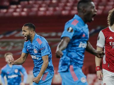 Striker Olympiakos, Youssef El-Arabi (kiri) melakukan selebrasi usai mencetak gol ke gawang Arsenal dalam laga leg kedua babak 16 besar Liga Europa 2020/2021 di Emirates Stadium, London, Kamis (18/3/2021). Olympiakos menang 1-0 atas Arsenal. (AP/Matt Dunham)
