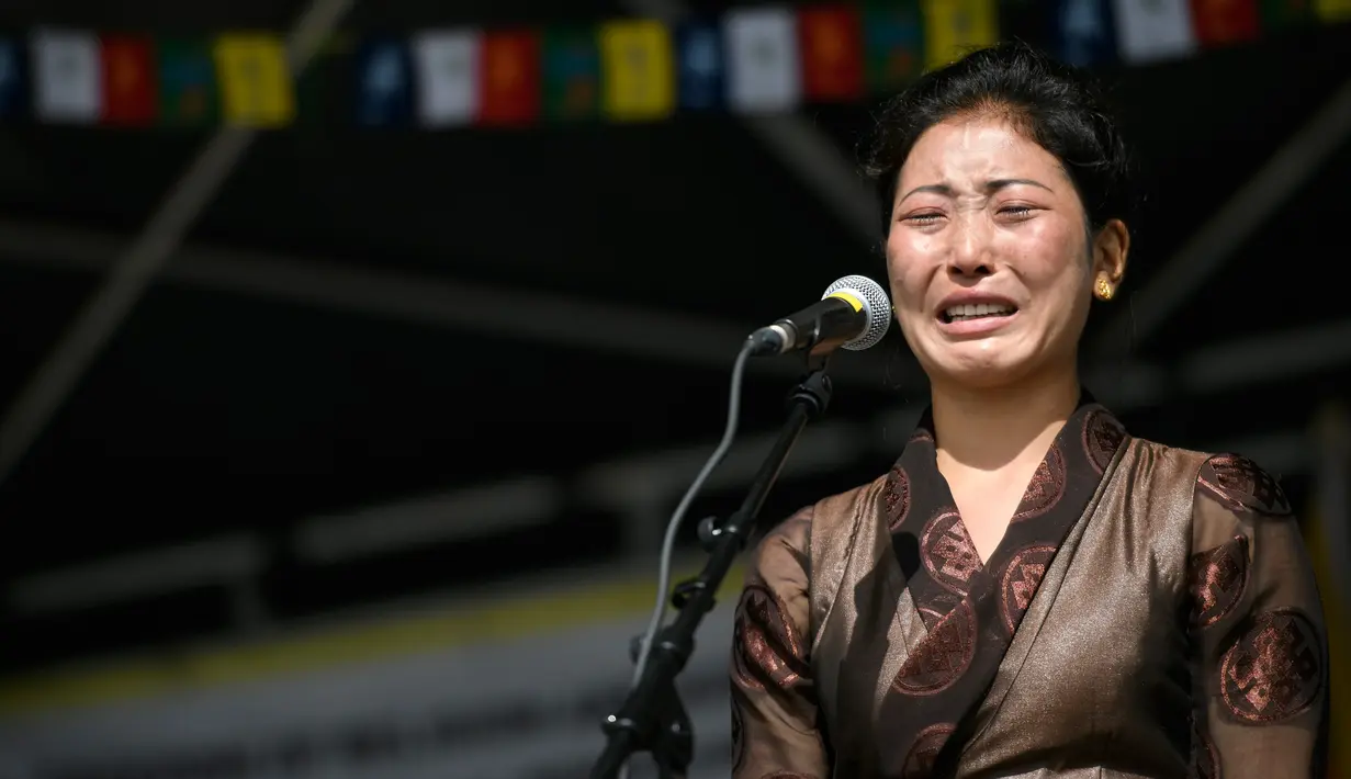 Seorang pengunjuk rasa  berpidato di depan kantor PBB di Jenewa, Jumat (16/9). Pengunjuk rasa meminta Presiden Tiongkok, Xi Jinping untuk menghentikan pembunuhan di Tibet. (AFP PHOTO/Fabrice Coffrini)