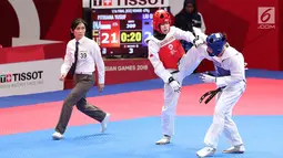 Atlet taekwondo putri Indonesia, Fitriyana Yusuf melayangkan tendangannya ke arah Liu Qing dari Makau pada babak 16 besar di Jakarta Convention Center (JCC), Senin (20/8). Fitriyana kalah tipis 21 - 25 pada kelas Wanita 67 kg. (Liputan6.com/Fery Pradolo)