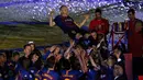 Pemain Barcelona melempar Andres Iniesta ke udara pada momen perpisahan usai laga penutup La Liga Spanyol melawan Real Sociedad di Stadion Camp Nou, Minggu (20/5). Iniesta resmi meninggalkan Barcelona setelah 22 tahun berkarier di sana (AP/Manu Fernandez)