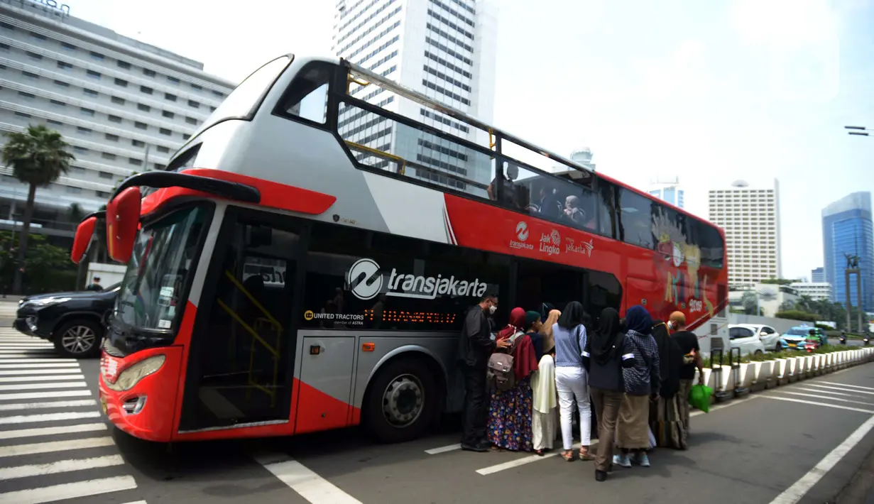 <p>Warga antre untuk menaiki bus tingkat Transjakarta dengan atap terbuka di Jakarta, Selasa (10/5/2022). Selama libur Lebaran, bus wisata tersebut melayani warga menuju berbagai rute destinasi wisata Ibu Kota. (merdeka.com/Imam Buhori)</p>