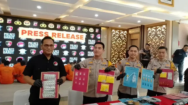 Kapolres Garut, AKBP Rohman Yonky Dilatha bersama Kasat Narkoba Polres Garut, AKP Juntar Hutasoit, menunjukan barang bukti dalam rilis kasus di Mapolres Garut. (Liputan6.com/Jayadi Supriadin)