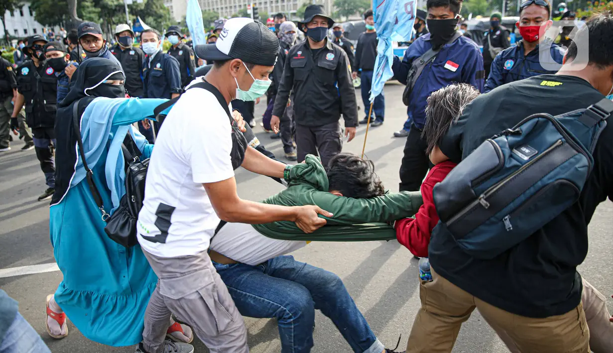 Petugas kepolisian mengamankan massa yang diduga hendak berbuat kericuhan saat aksi unjuk rasa di kawasan Patung Kuda, Jakarta, Kamis (22/10/2020). Penangkapan dilakuka  untuk mencegah hal hal yang tak di inginkan saat unjuk rasa. (Liputan6.com/Faizal Fanani)