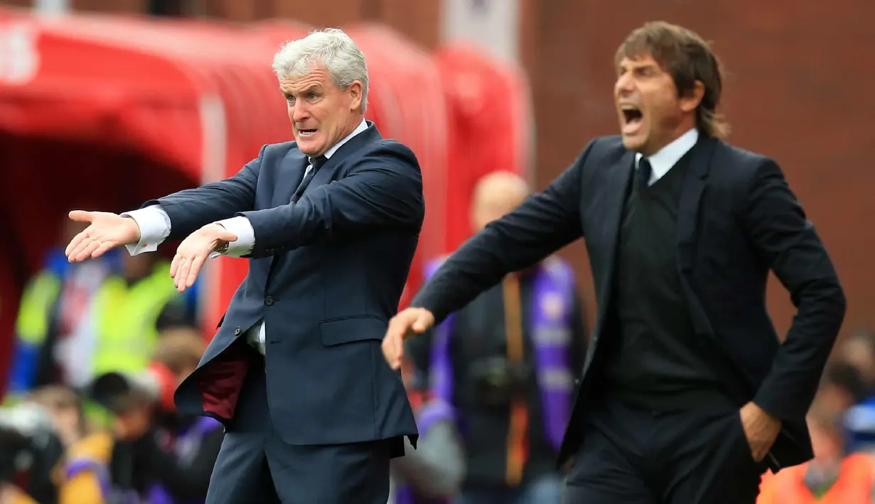 Pelatih Stoke City, Mark Hughes (kiri) dan pelatih Chelsea, Antonio Conte memberi intruksi ke para pemainya saat bertanding pada lanjutan Liga Inggris di Stadion Bet365 di Stoke-on-Trent, (23/9). Chelsea menang 4-0 atas Stoke. (AFP Photo/Lindsey Parnaby)