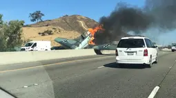 Kendaraan melintas di dekat pesawat antik Amerika Utara AT-6 yang terbakar di US 101 di Agoura Hills, California (23/10). AFP Photo/Cynthia Alvarez)