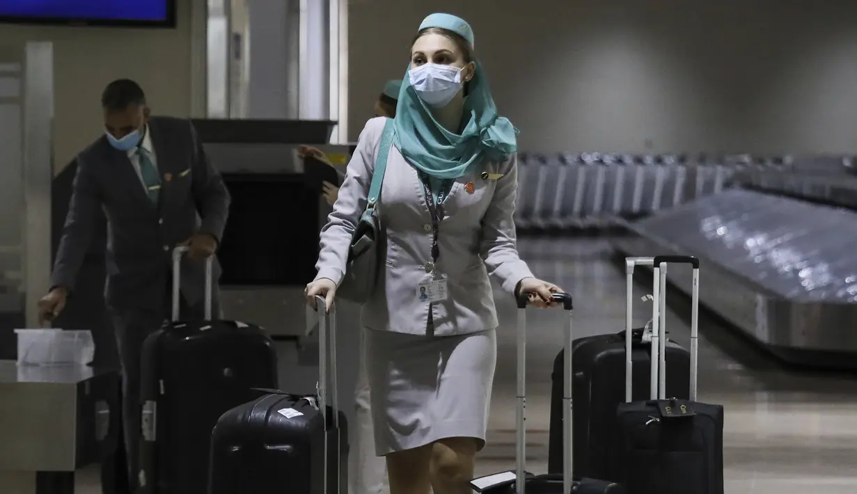 Seorang pramugari yang mengenakan masker pelindung tiba di Bandara Internasional Manila, Filipina, Kamis (10/2/2022). Filipina mulai hari ini membuka kembali pintu bagi turis asing setelah hampir dua tahun menutup perbatasannya. (AP Photo/Basilio Sepe)