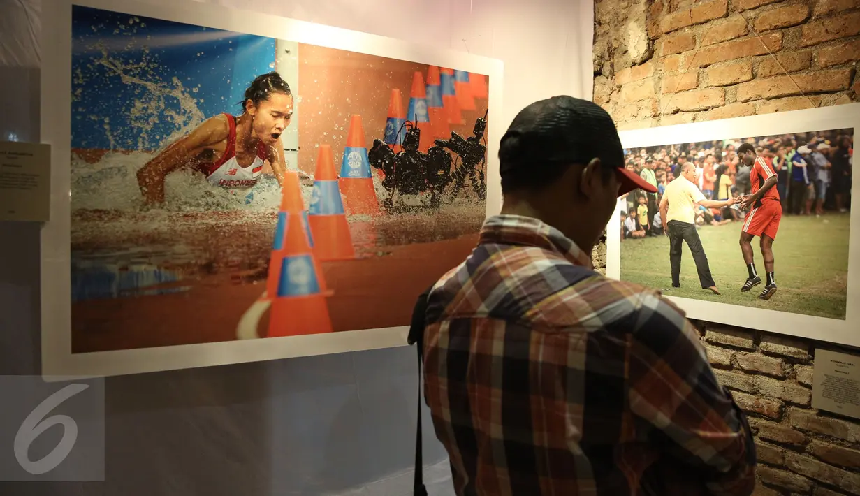 Pengunjung memperhatikan karya foto pada pameran foto Anugerah Pewarta Foto Indonesia (APFI) ke-VI di Gedung De Vries, Bandung, Sabtu (9/4). APFI 2016 memamerkan 25 foto tunggal dan tiga foto seri terbaik sepanjang  2015. (Liputan6.com/Faizal Fanani)
