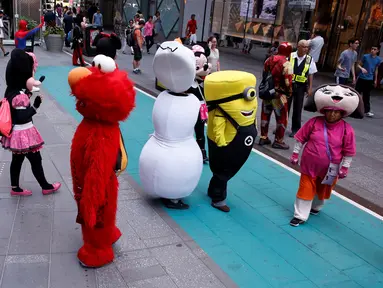 Sejumlah karakter kartun berada di jalanan untuk menghibur pengunjung di Times Square, New York, Selasa (21/6). Kehadiran karakter-karakter kartun tersebut mengundang warga untuk foto bersama. (REUTERS/Lucas Jackson)