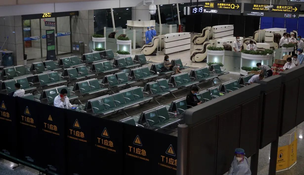 Orang-orang duduk di area tertutup sementara untuk kerabat korban pesawat China Eastern penerbangan MU5735 yang jatuh, di Bandara Internasional Baiyun, Guangzhou, Senin (21/3/2022). Ada 132 orang di dalam penerbangan tersebut, terdiri dari 123 penumpang dan sembilan awak kabin (Chinatopix Via AP)