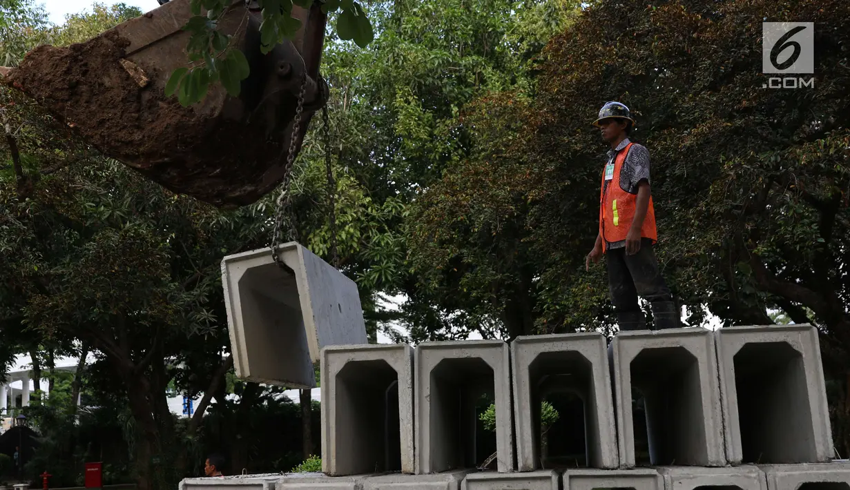Pekerja mengamati alat berat melakukan perbaikan drainase Kompleks Istana Kepresidenan, Jakarta, Senin (18/12). Pengerjaan rehabilitasi drainase kawasan istana kepresidenan tersebut guna mengantisipasi ancaman banjir. (Liputan6.com/Angga Yuniar)