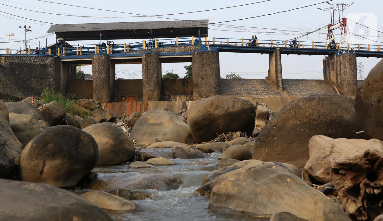 Warga berkendara motor melintasi Bendung Katulampa, Kota Bogor, Jawa Barat, Senin (3/8/2020). Debit air sungai Ciliwung di Bendung Katulampa mengalami penyusutan sejak satu bulan terakhir memasuki awal musim kemarau dengan ketinggan air 0 cm. (Liputan6.com/Helmi Fithriansyah)