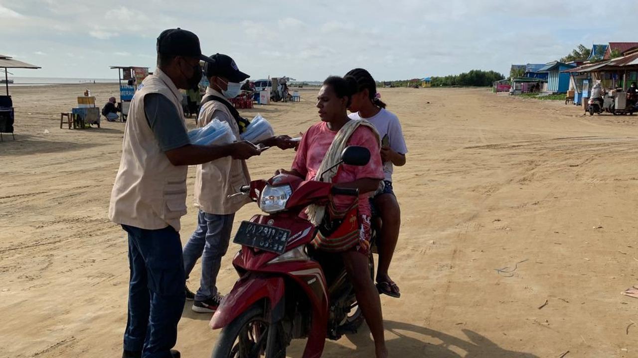 Relawan Prokes Salerus Kamogou Membagikan Masker di Merauke, Papua.