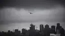 Sebuah pesawat amfibi lepas landas dari pelabuhan di bawah awan rendah di atas cakrawala pusat kota, di Vancouver, British Columbia, Kamis, (6/8/2020). (Darryl Dyck / The Canadian Press via AP)