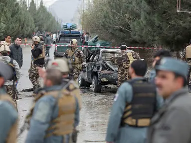 Petugas keamanan setempat memeriksa lokasi bom bunuh diri di Kabul, Afghanistan (15/11). Akibat bom bunuh diri ini sedikitnya sembilan orang tewas dan sebagian lainnya mengalami luka-luka. (AP Photo/Rahmat Gul)