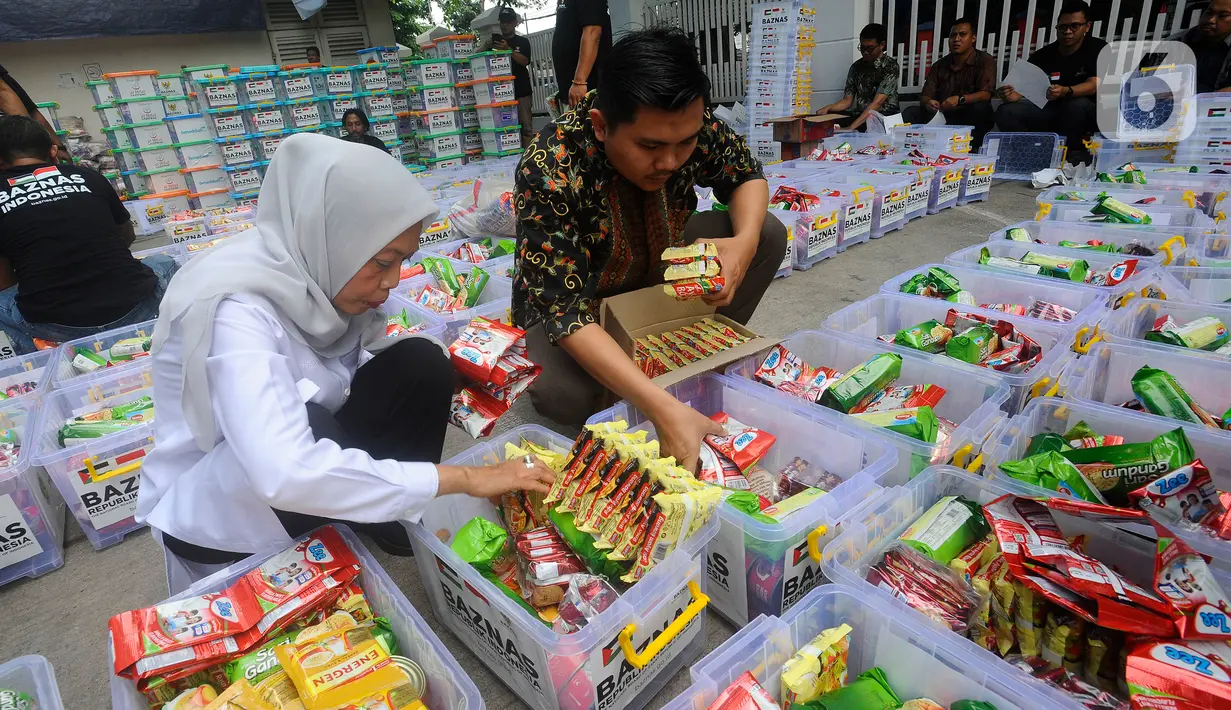 Pimpinan Baznas Bidang Pendistribusian dan Pendayagunaan Saidah Sakwan (kiri) bersama relawan mengemas bahan makanan yang akan dikirim ke Palestina di Kantor Baznas, Jakarta, Kamis (2/11/2023).  (merdeka.com/Arie Basuki)