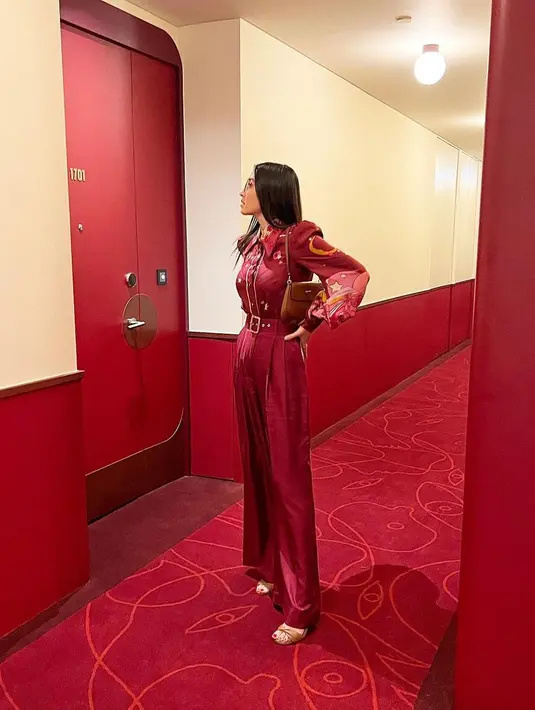 Inspirasi outfit nuansa merah yang simpel tapi elegan, bisa tiru gaya Raline Shah satu ini. Pilih jumpsuit warna merah bermotif yang yang dipadukan dengan shoulder bag warna coklat. [@ralineshah]