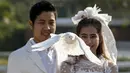 Sepasang pengantin melepaskan burung merpati saat upacara pernikahan di provinsi Ratchaburi, Thailand, Sabtu (13/2). Upacara pernikahan tersebut diikuti oleh empat pasang pengantin untuk menyambut Hari Valentine. (REUTERS/Athit Perawongmetha)