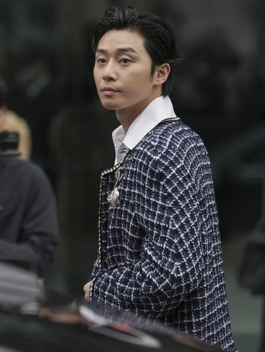 Park Seo-joon menghadiri peragaan busana Chanel untuk koleksi Fall-Winter 2023/24 di Paris Fashion Week, Selasa (7/3/2023). Jaket tweed bintang Marvel ini dilengkapi dengan pin bros berlogo Chanel. (Scott Garfitt/Invision/AP)