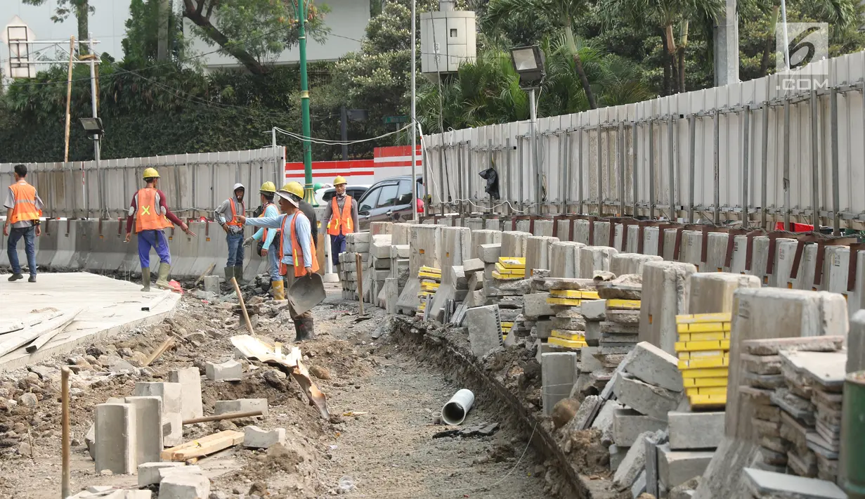 Pekerja menyelesaikan proyek revitalisasi trotoar di kawasan Bundaran Hotel Indonesia, Jakarta, Selasa (24/9/2019). Pemerintah Provinsi (Pemprov) DKI tengah mengebut pembangunan revitalisasi trotoar di sejumlah titik Ibu Kota yang ditargetkan rampung akhir 2019 mendatang. (Liputan6.com/Angga Yuniar)