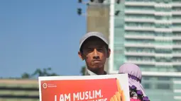 Seorang lelaki menggendong bayi ikut menolak Valentine Day di Kawasan Bundaran HI, Jakarta, Minggu (14/2/2016). Mereka menilai perayaan Valentine Day kerap menjurus pada perilaku seks bebas dan merusak moral. (Liputan6.com/Gempur M Surya)