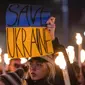 Seorang wanita memegang spanduk saat demonstrasi untuk Ukraina yang diselenggarakan oleh Greenpeace di Heroes Square, Budapest, Hungaria, 9 Maret 2022. Lebih dari 1,5 juta orang telah menyeberang dari Ukraina ke negara-negara tetangga. (AP Photo/Anna Szilagyi)