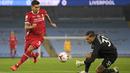 Penyerang Liverpool, Roberto Firmino mencoba untuk melewati kiper Manchester City Ederson pada pertandingan Liga Inggris pekan ke-8 di Etihad Stadium, Minggu (8/11/2020). Manchester City gagal mengalahkan Liverpool dan harus puas berbagi angka setelah bermain imbang 1-1 (Shaun Botterill/Pool via AP)