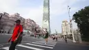 Warga memakai masker untuk melindungi dari penyebaran COVID-19 saat melewati Gedung Taipei 101 di Taipei, Taiwan, Sabtu (15/5/2021). Taiwan yang membuat iri dalam menahan COVID-19 memberlakukan pembatasan baru di ibu kota saat memerangi wabah terburuk sejak pandemi. (AP Photo/Chiang Ying-ying)