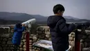 Dua anak laki-laki melihat teropong di atap vila yang dikenal sebagai Kastil Hwajinpo di Pantai Hwajinpo, Korea Selatan, (19/2). Villa ini termasuk dalam wilayah Korea Utara sebelum perang tahun 1950- 53. (AP Photo/Jae C. Hong)