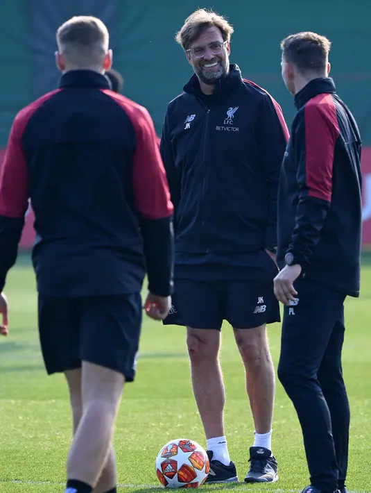 Manajer Liverpool Jurgen Klopp (tengah) tersenyum ketika mengikuti sesi latihan tim jelang menghadapi FC Porto pada leg pertama perempat final Liga Champions di Melwood, Liverpool, Inggris, Senin (8/4). The Reds bertekad membungkam Porto di Stadion Anfield. (Paul ELLIS/AFP)