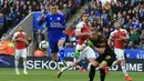 Striker Leicester City, Jamie Vardy, berebut bola dengan kiper Arsenal, Bernd Leno, pada laga Premier League di Stadion King Power, Minggu (28/4). Leicester City menang 3-0 atas Arsenal. (AFP/Lindsey Parnaby)