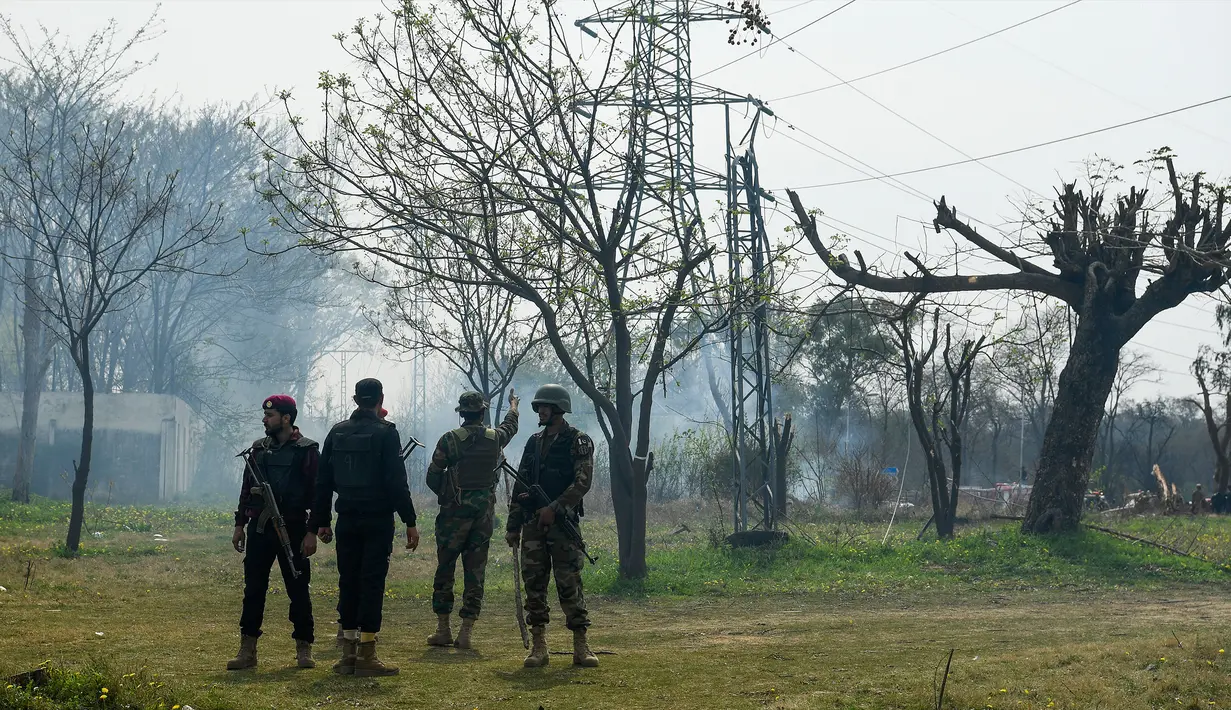 Tentara mengamankan lokasi jatuhnya jet tempur F-16 Pakistan saat latihan jelang parade militer Hari Pakistan di Islamabad, Rabu (11/3/2020). Belum ada konfirmasi lebih lanjut bagaimana nasib pilot dan co-pilot pesawat nahas tersebut. (Aamir QURESHI/AFP)