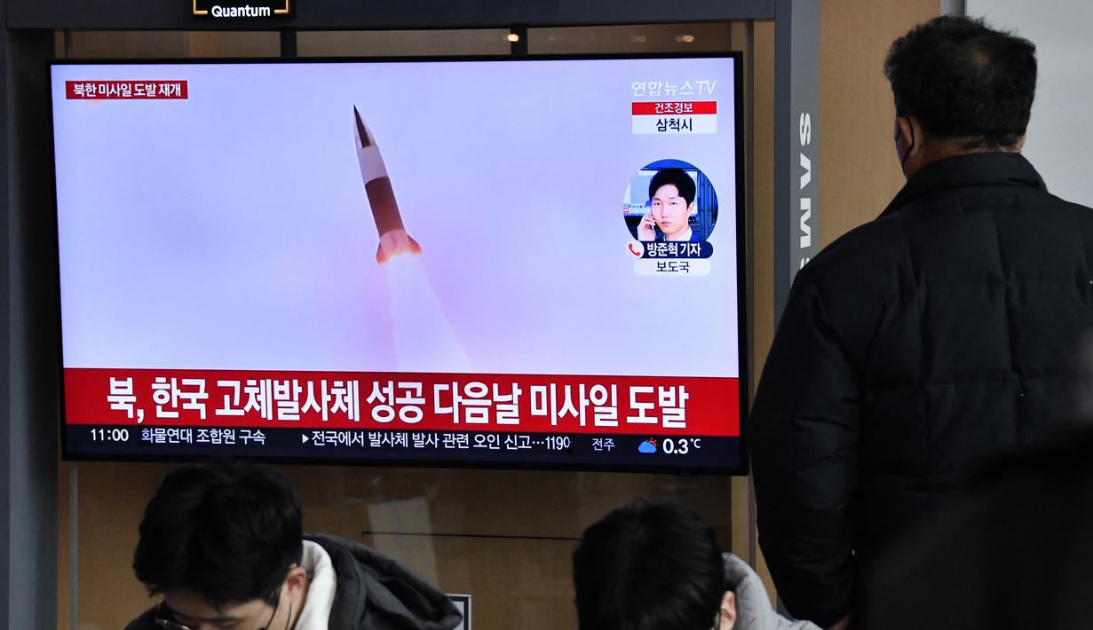Seorang pria menonton layar televisi yang menayangkan siaran berita dengan rekaman file uji coba rudal Korea Utara, di sebuah stasiun kereta api di Seoul, Sabtu (31/12/20220). Ketiga rudal balistik jarak dekat itu dilaporkan jatuh ke perairan sebelah timur Semenanjung Korea. (Jung Yeon-je / AFP)